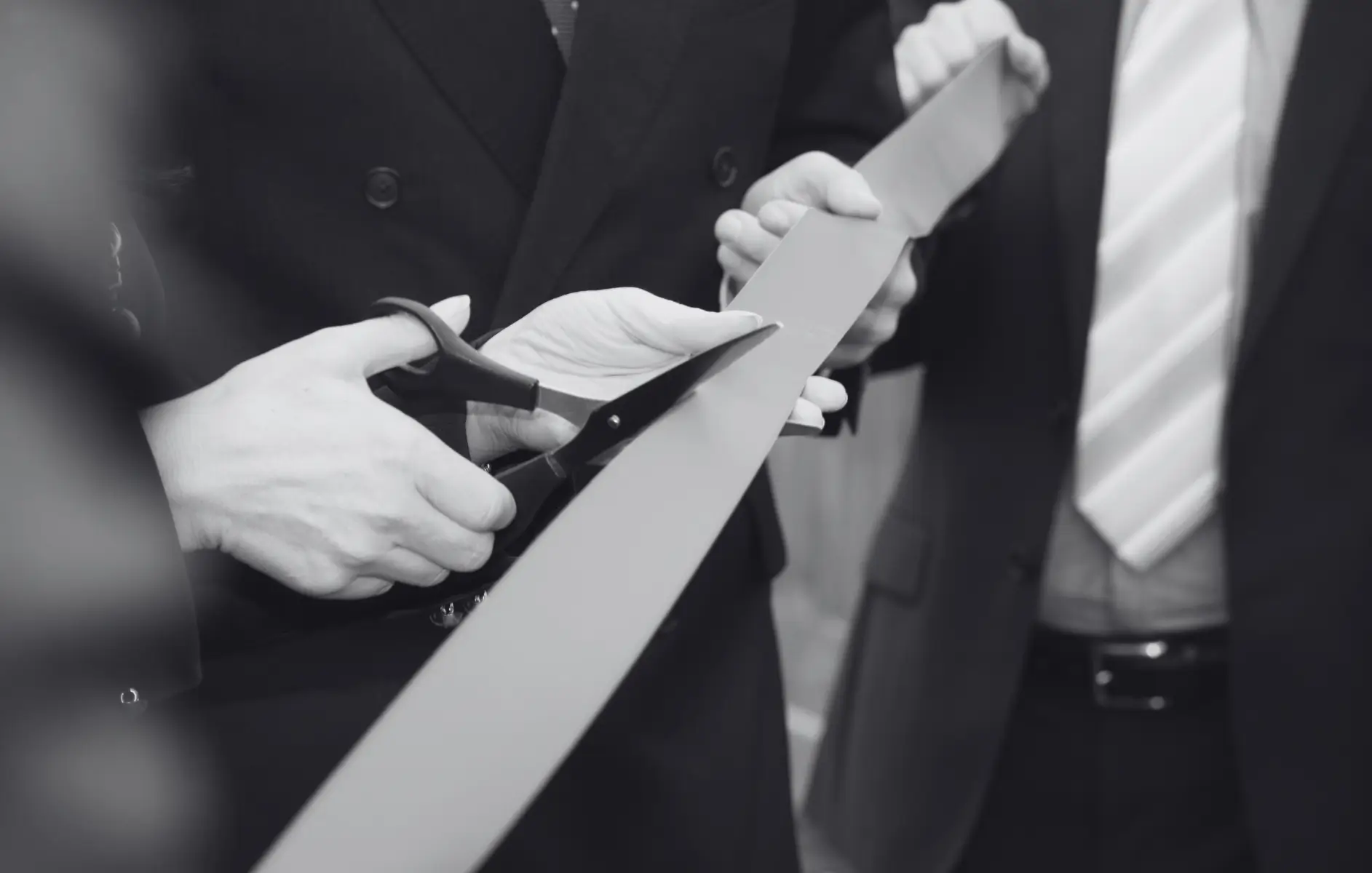 Startschuss: Produktneulaunch mit Sonderanfertigungenv Nahaufnahme von Händen, die ein Band bei einer feierlichen Eröffnungszeremonie durchschneiden – ein Symbolbild für einen erfolgreichen Produktneulaunch, begleitet von einer exklusiven Werbeartikel Sonderanfertigung.