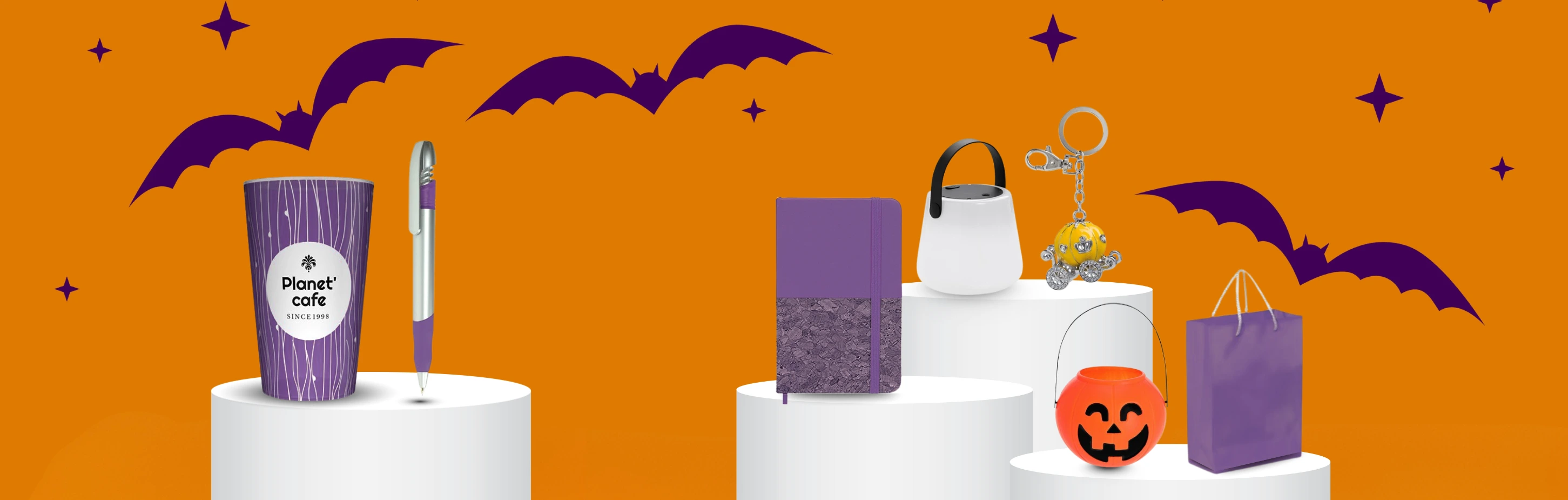 Breites Banner mit Fledermaus-Hintergrund, das eine diverse Halloween Werbeartikel Auswahl präsentiert: Vom lila Becher über Notizbücher bis hin zum leuchtenden Kürbis-Eimer.