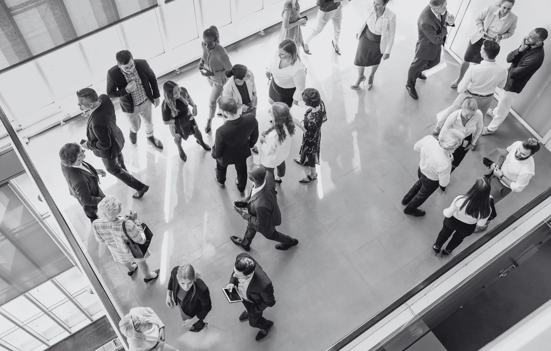 Schwarz-Weiß-Collage: Oben ein großes, beleuchtetes Messe- und Kongresszentrum bei Nacht, unten ein geschäftlicher Handschlag zwischen zwei Partnern, Symbolbild für den erfolgreichen Einsatz einer Werbeartikel Sonderanfertigung auf einer Messe.